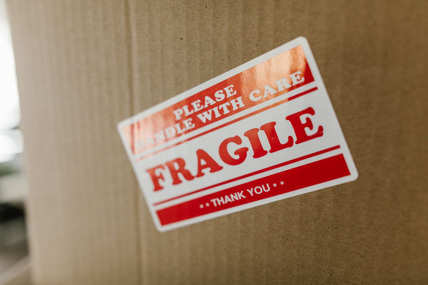 custom stickers in any shape — Close-up of a cardboard box with a 'fragile' sticker indicating careful handling