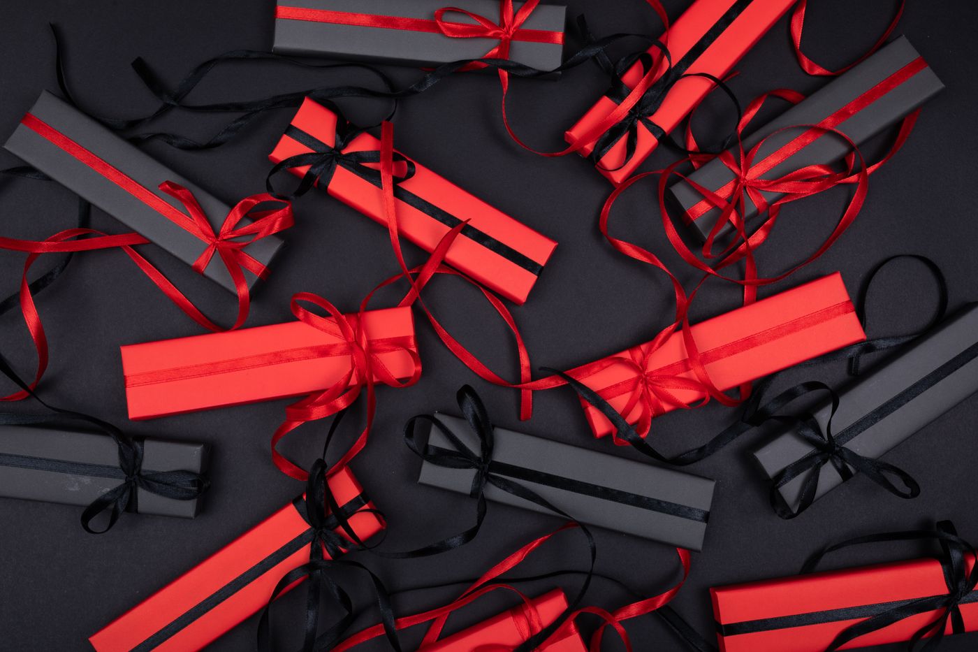 name tag keychain for backpack — Top view of elegantly arranged red and black gift boxes with ribbons, creating a festive and sophisticated look