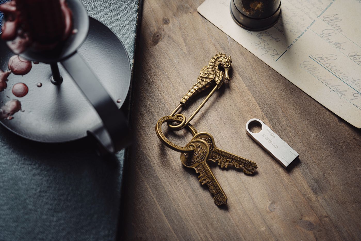 3d printed keychain custom name — Artistic shot of a vintage seahorse keyring with keys on a wooden table, alongside candle and letter