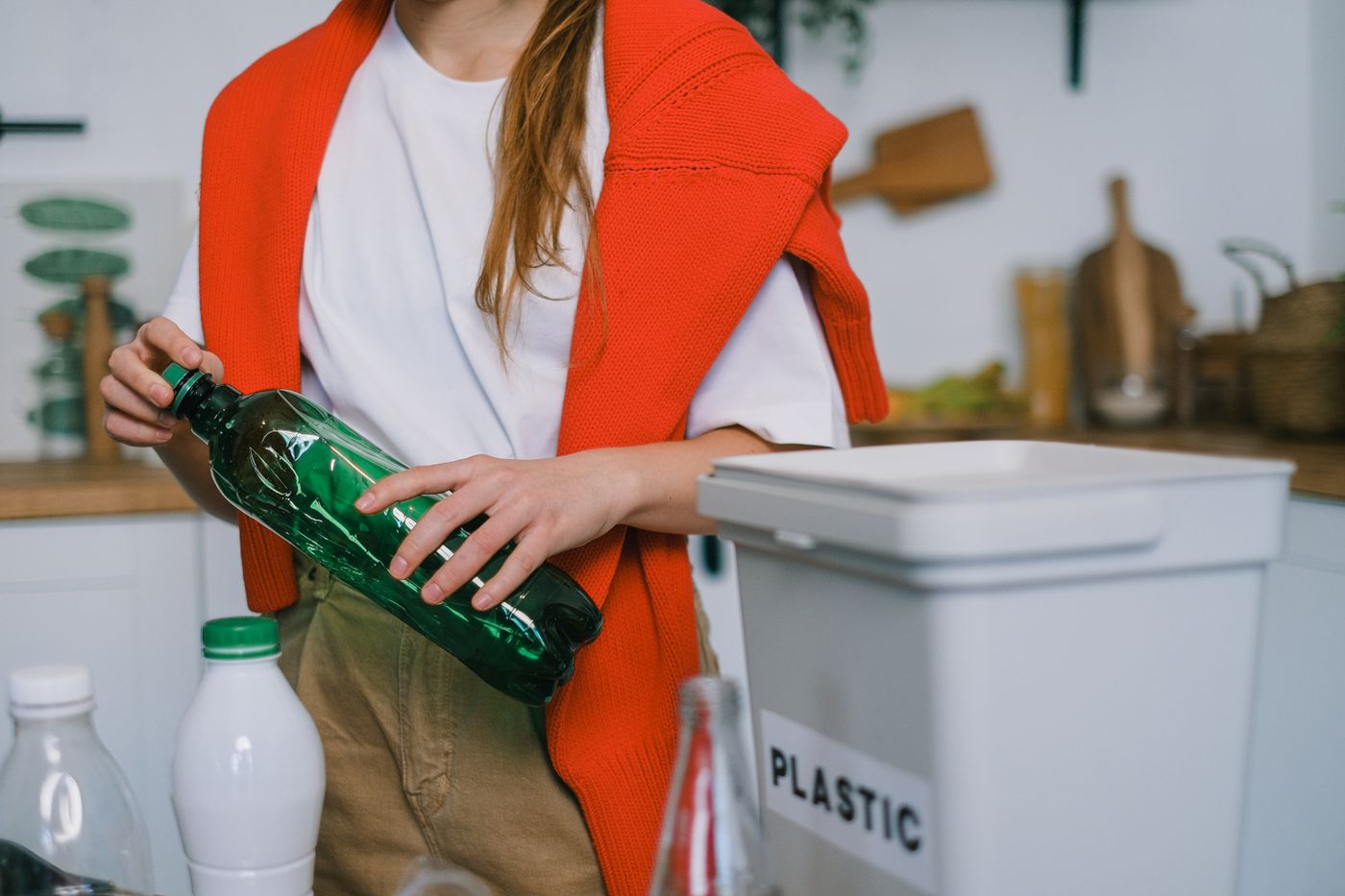 resin 3d printing safety — Crop anonymous female in casual clothes standing with plastic bottle while sorting garbage in light kitchen in daytime