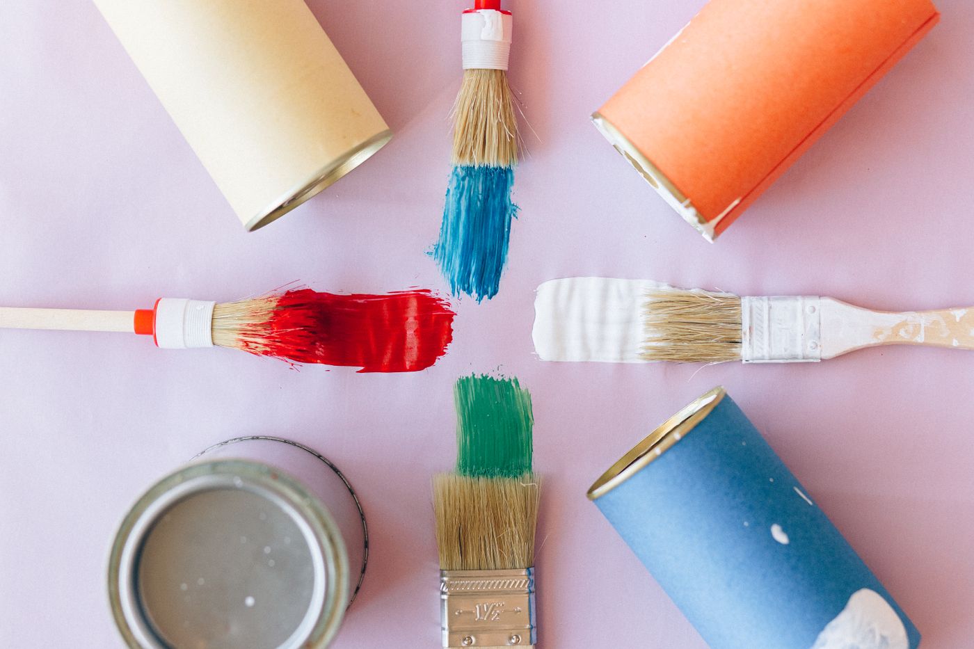 can you paint 3d printed items — Top view of vibrant paintbrushes and cans against a pastel backdrop, ideal for creative projects