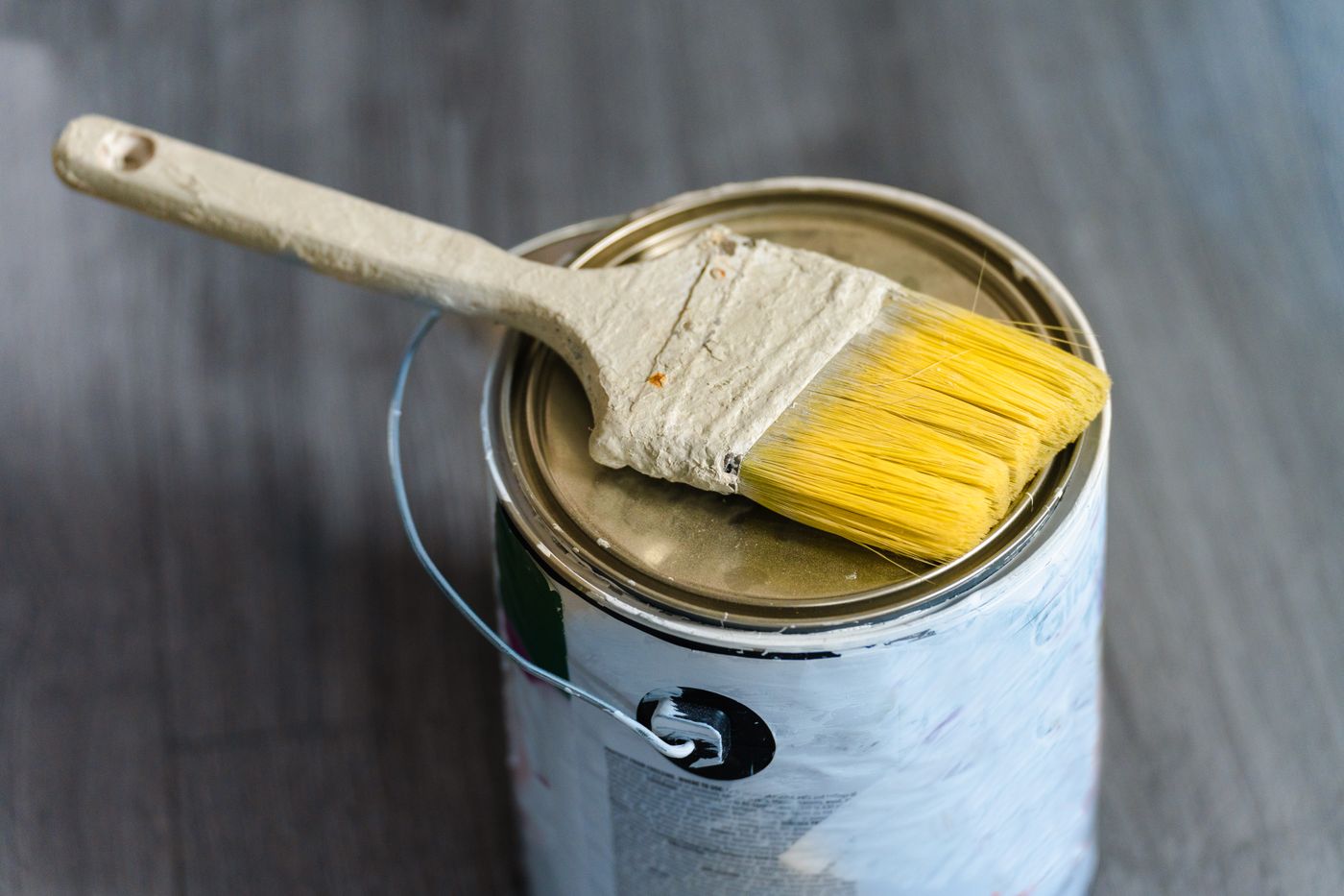 can you paint 3d printed items — A close-up image of a paintbrush resting on a paint can, ideal for DIY projects