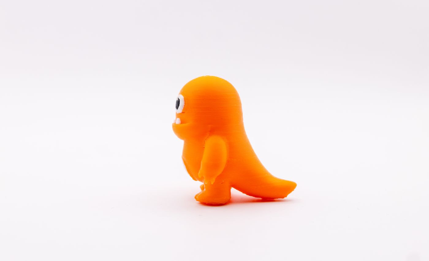 3d printed gift for 8 year old girl — Bright orange toy dinosaur figurine with cartoonish features on a white background