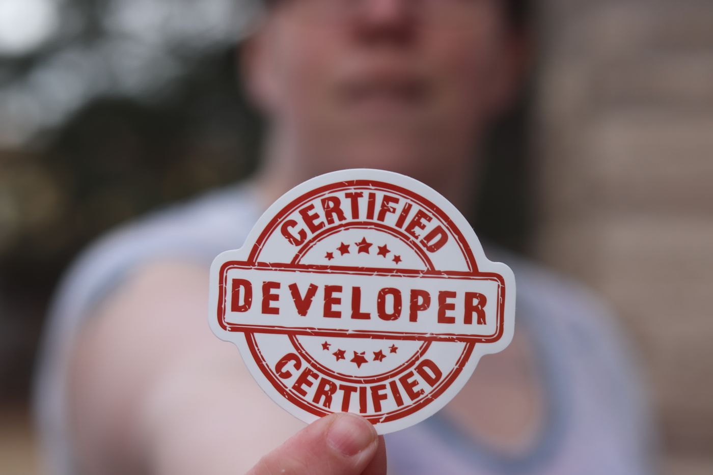 custom shape kiss cut stickers — Close-up of a certified developer badge being held outdoors