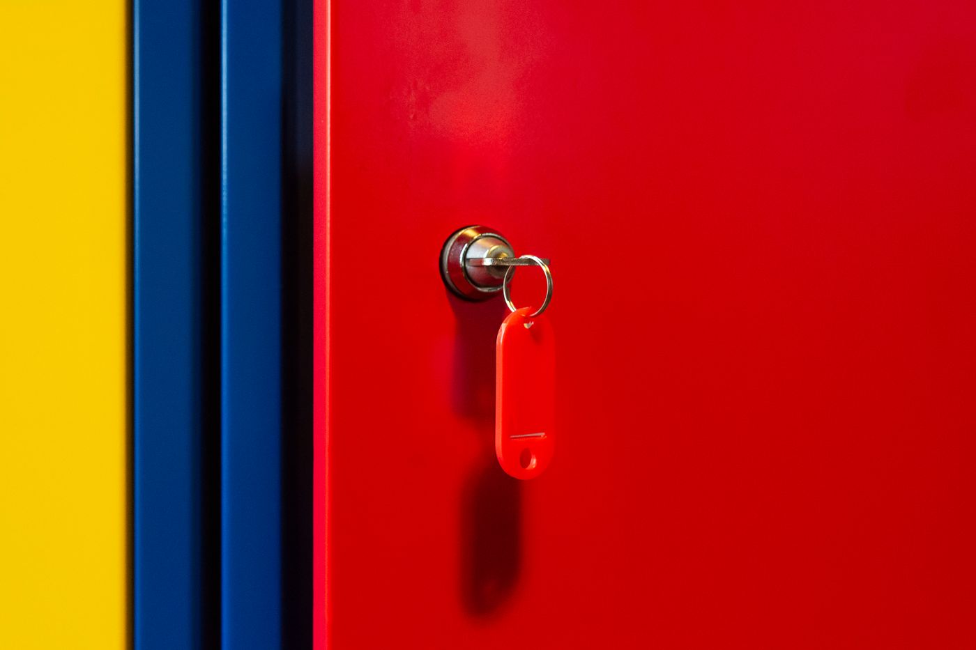 name keychain for water bottle — A vibrant image of a red locker door with a key in the lock, featuring bold primary colors