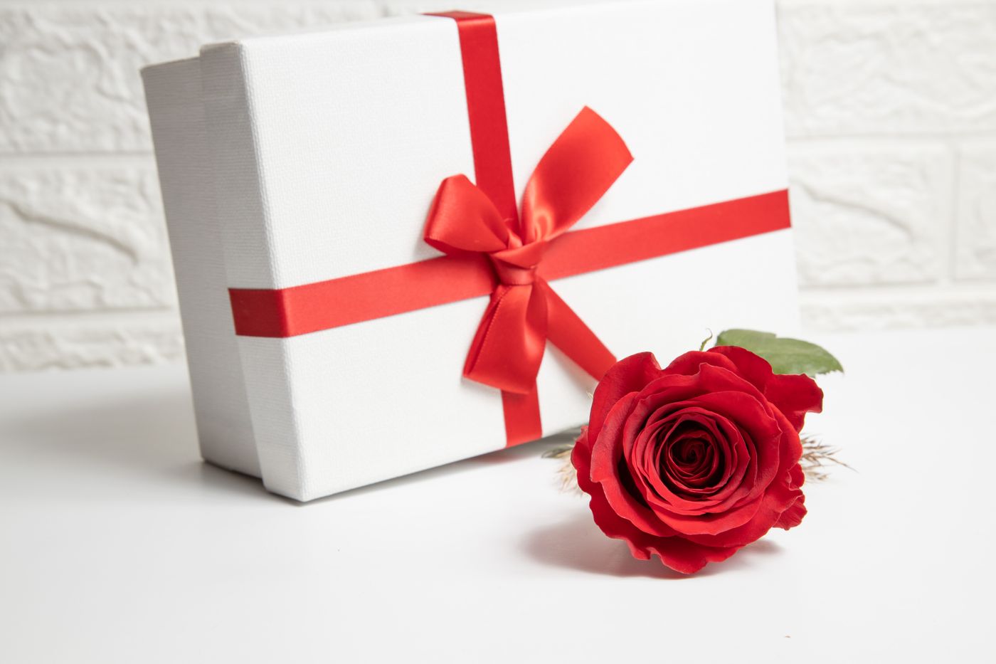 keychain gift for brother — A white gift box with a red ribbon and a vibrant red rose, ideal for Valentine's Day or special romantic occasions