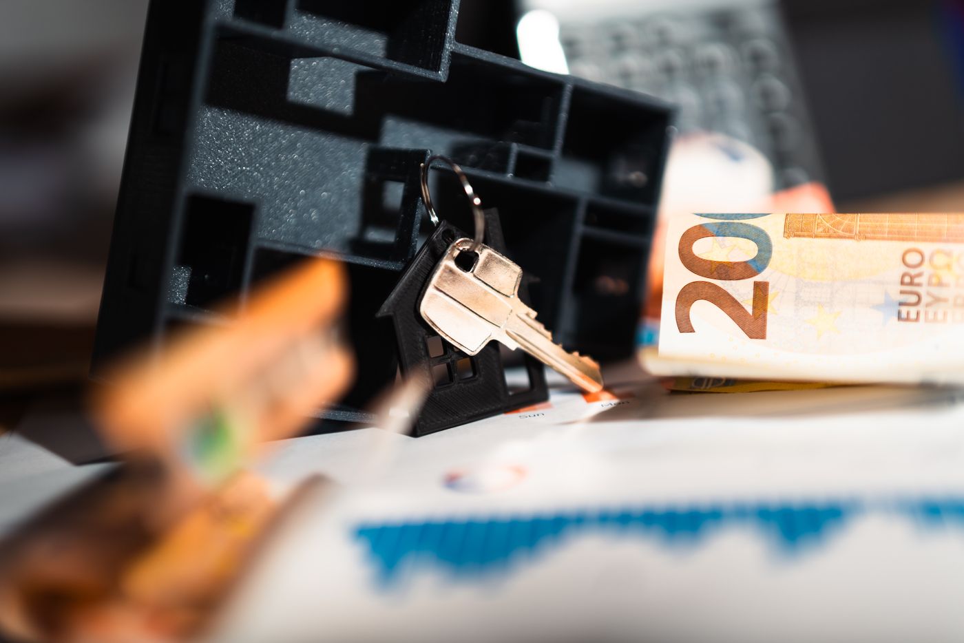 personalised keychain for house — Keys with a house model, Euro bills, and charts suggesting real estate and financial themes