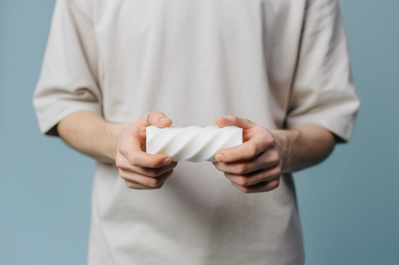 3d printer accessories gift — An adult holding a white textured object against a blue background