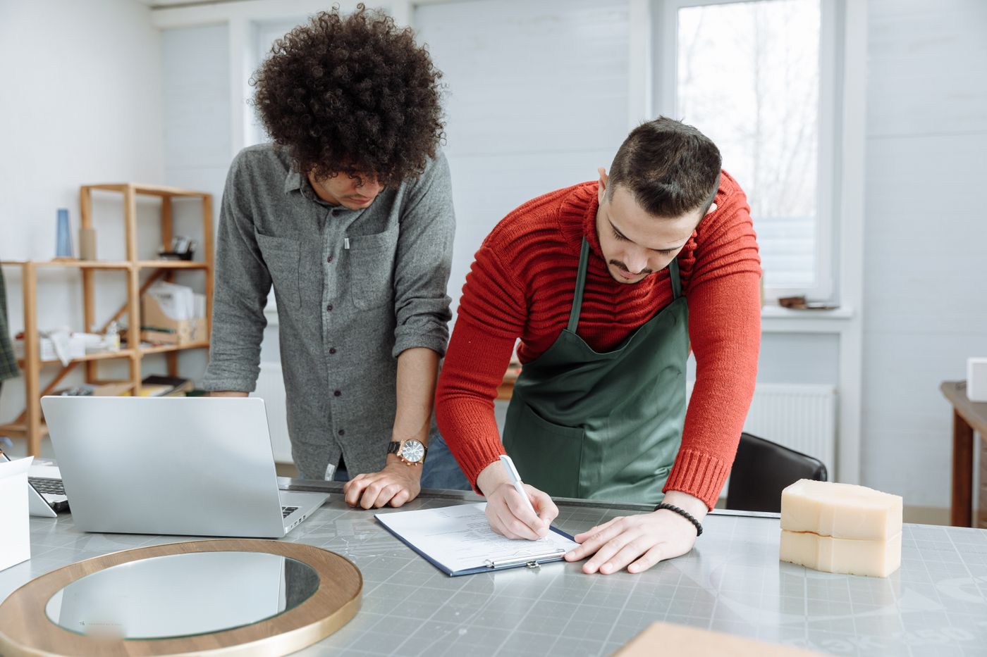 3d print for keychain — Two men working together at a desk, taking notes in a modern workshop environment