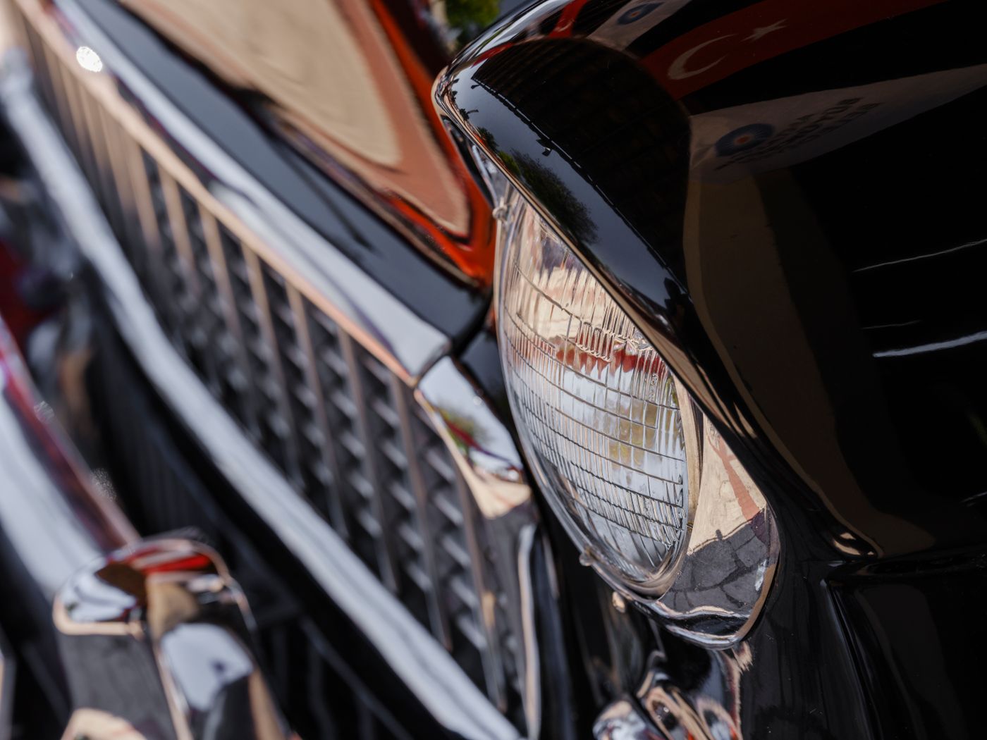 personalised keychain for car — Detailed close-up of a vintage car's shiny headlight and grille, reflecting its classic design