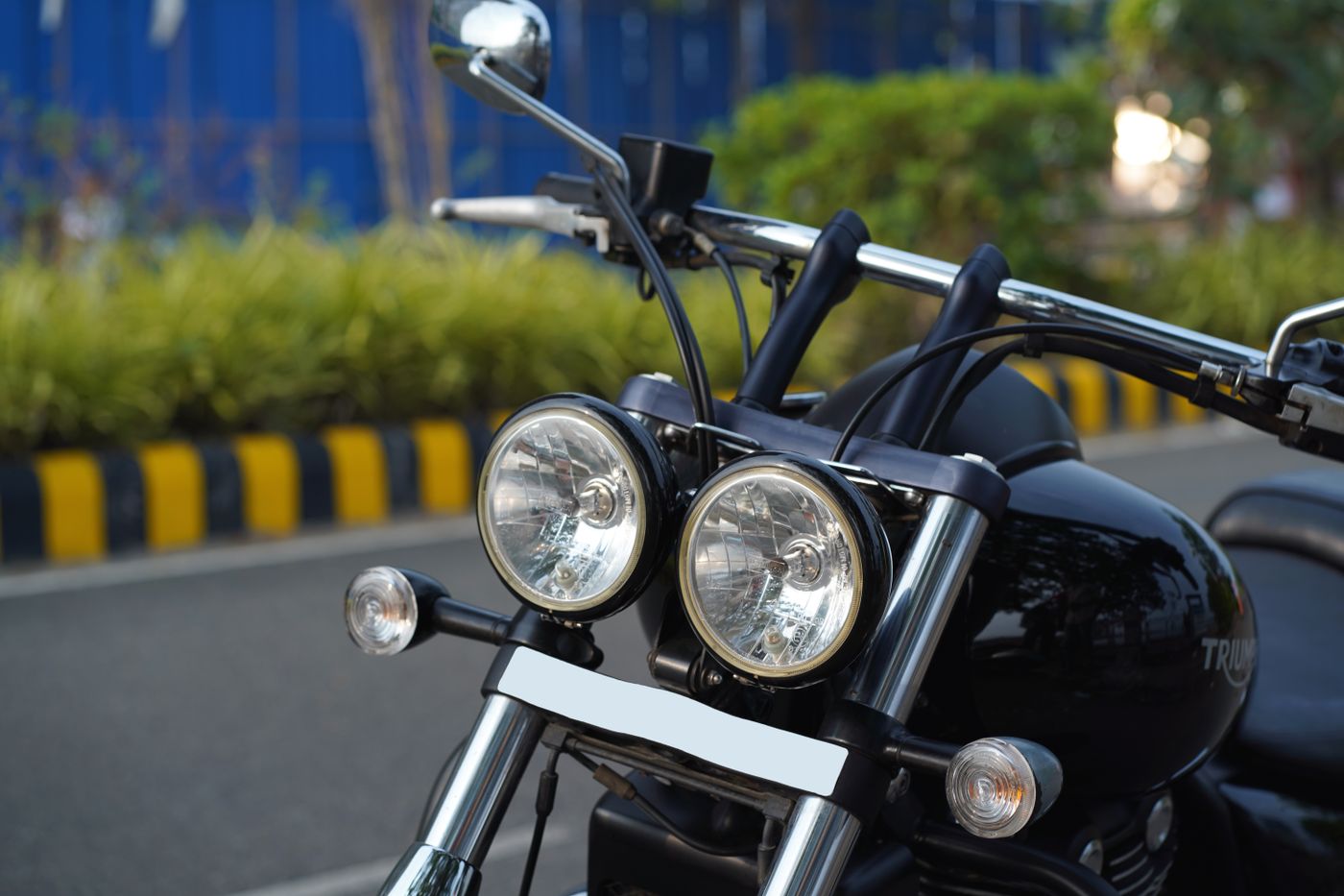 3d printed accessories for motorcycle — Detailed view of motorcycle handlebars and headlights with street background in India