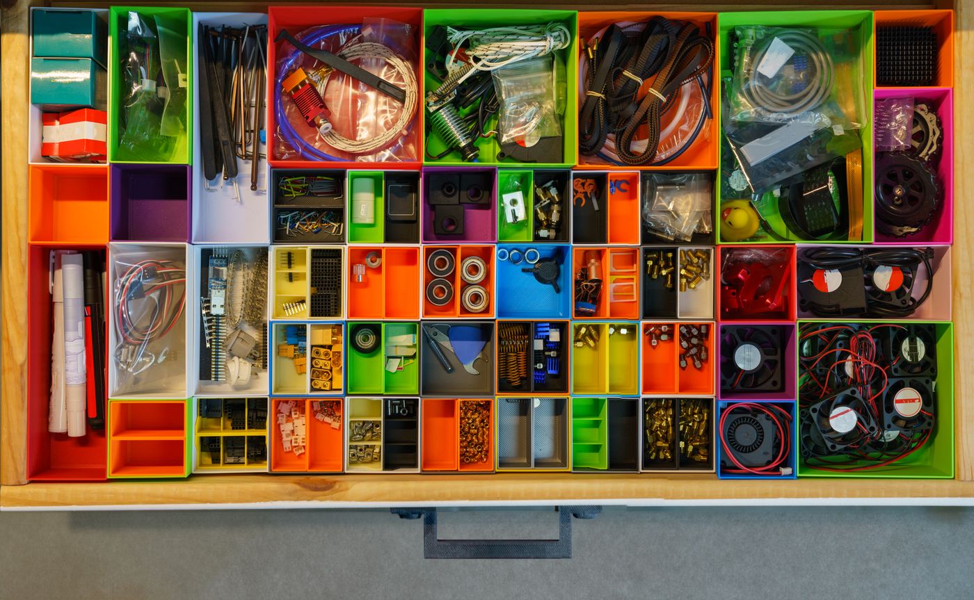 3d printed decorative box — Top view of a neatly organized drawer filled with colorful containers holding various tools and electronic parts