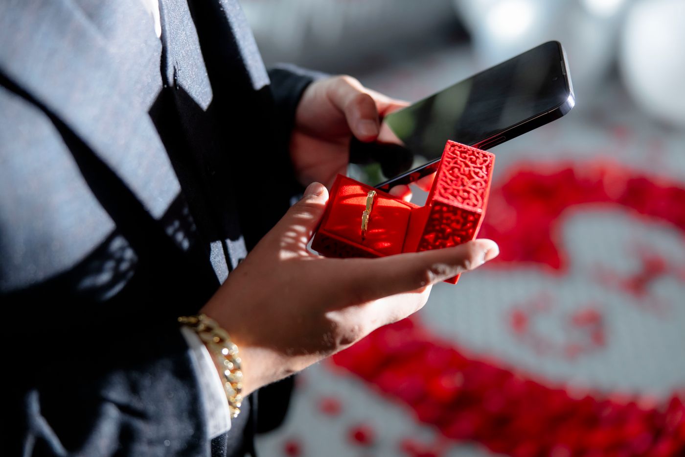 3d printed engagement gift ideas — A romantic moment capturing a wedding proposal with ring box in hand and smartphone