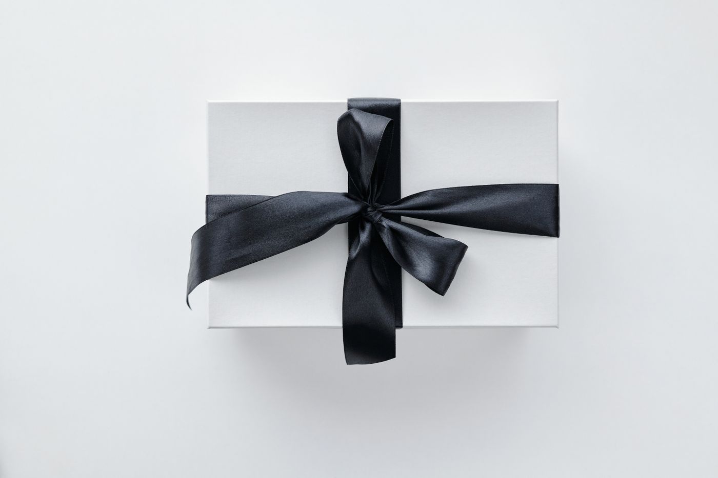 keychain gift for boyfriend — A stylish white gift box adorned with a black satin ribbon on a pure white background
