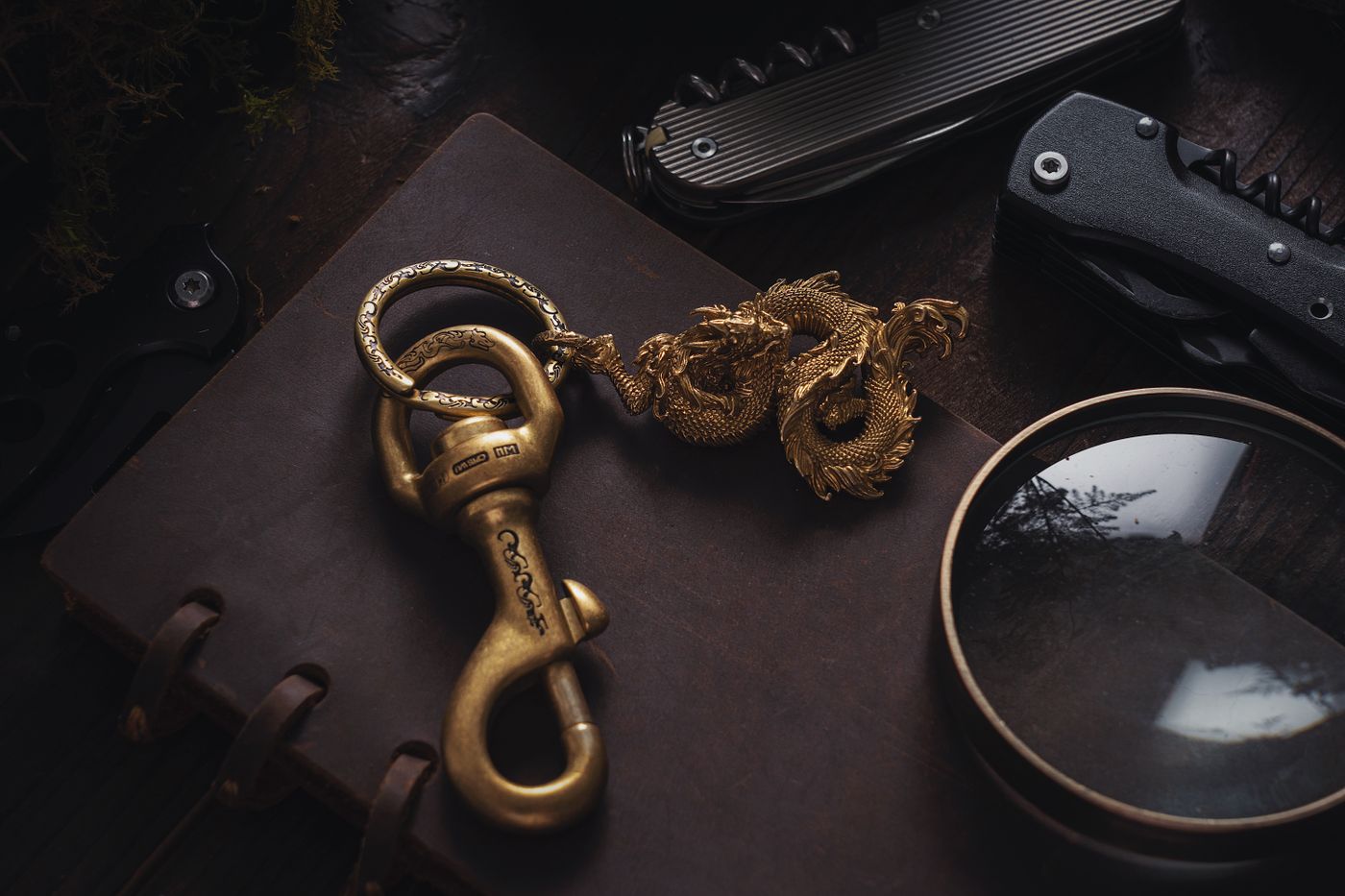keychain gift for boyfriend — A close-up of a golden dragon pendant and accessories on a rustic wooden desk, showcasing texture and craftsmanship