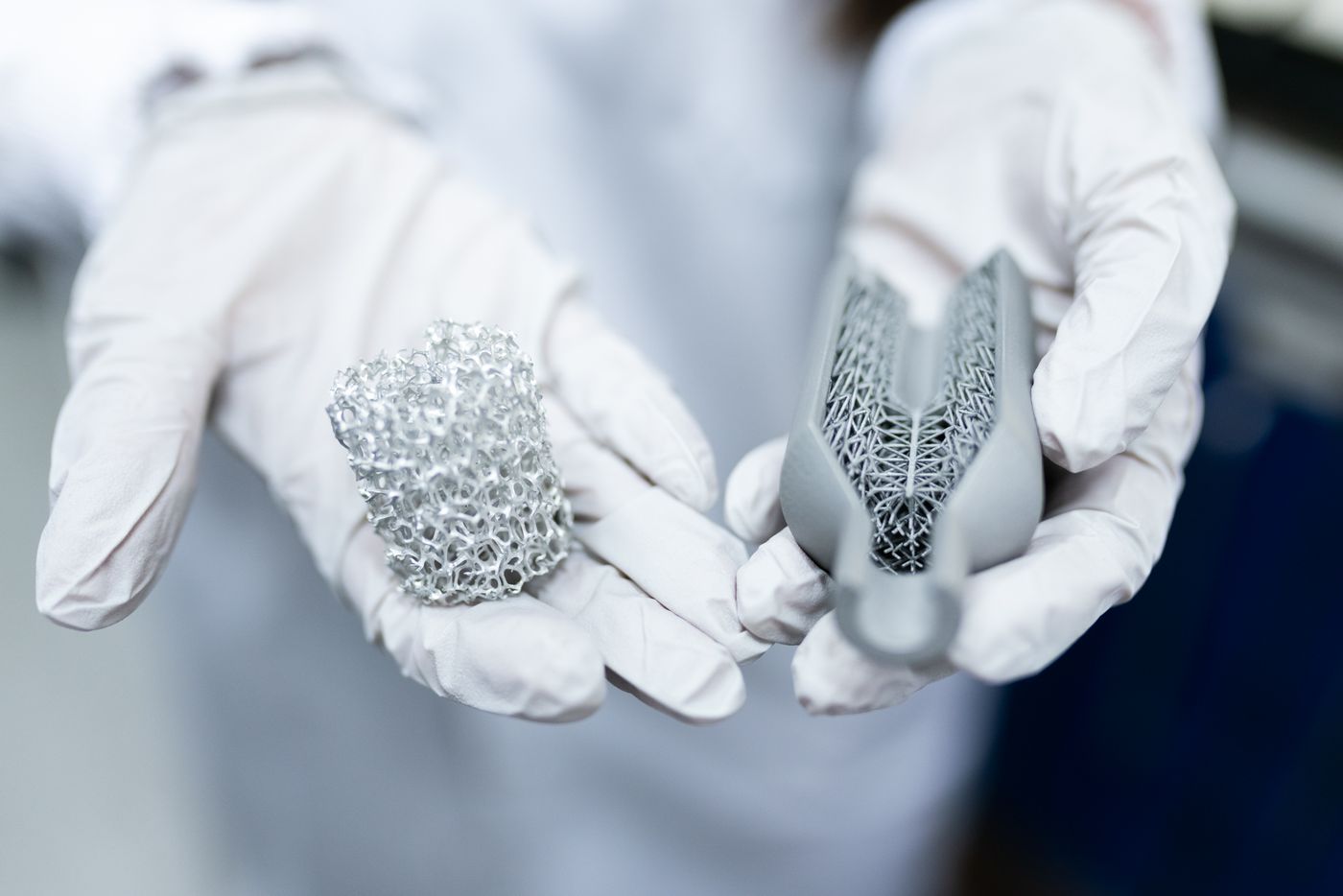 3d print design tips — Laboratory setting showing gloved hands holding innovative 3D printed metal structures
