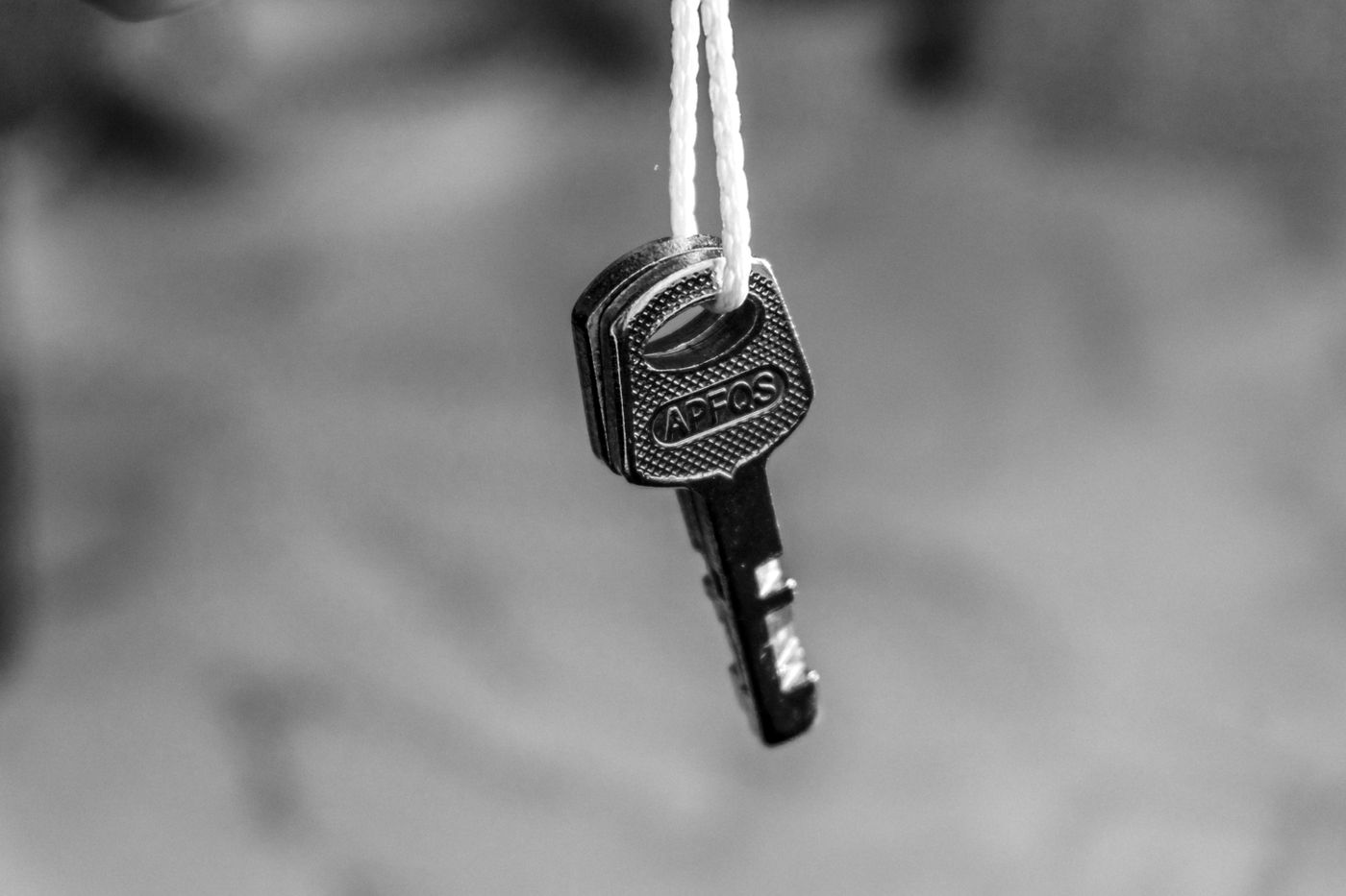 name keychain cricut — Monochrome image of a key hanging on a string, emphasizing security concepts