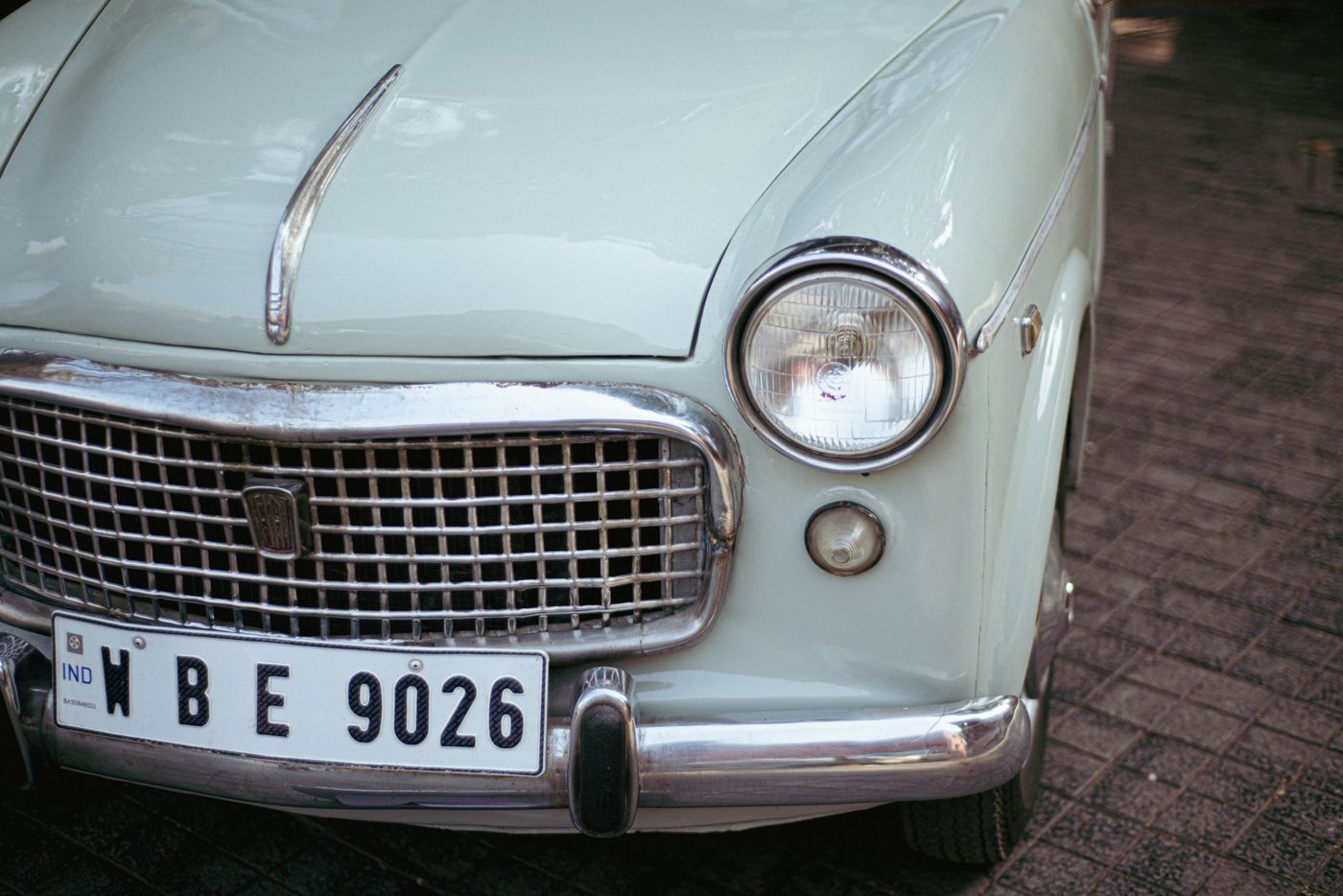 bumper stickers india — Detailed view of a classic vintage Fiat car front focusing on the headlight and grille