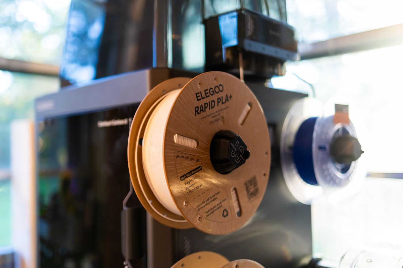 common 3d printing problems — Close-up view of a 3D printer with Elegoo Rapid PLA+ spool, ideal for tech enthusiasts