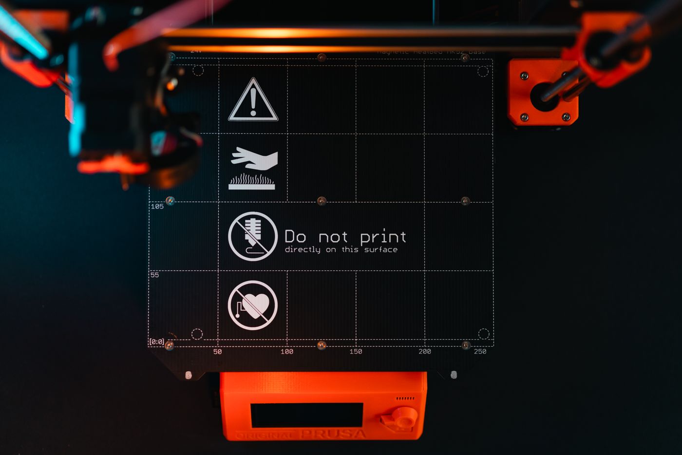 common 3d printing problems — 3D printer build plate with warning symbols, showcasing high-tech equipment in a workspace