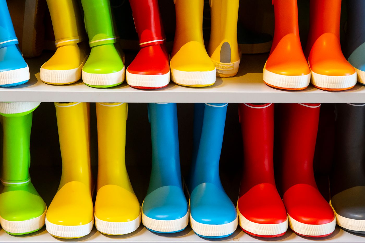 is pla waterproof — A vibrant collection of rubber rain boots in various colors neatly arranged on a shelf