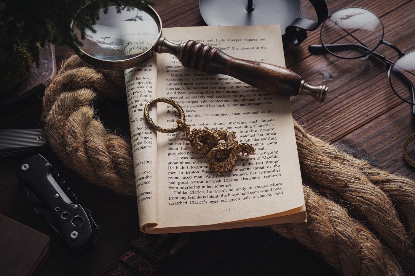 scooter keychain — Intricate still life with book, dragon figurine, magnifier, and rustic objects