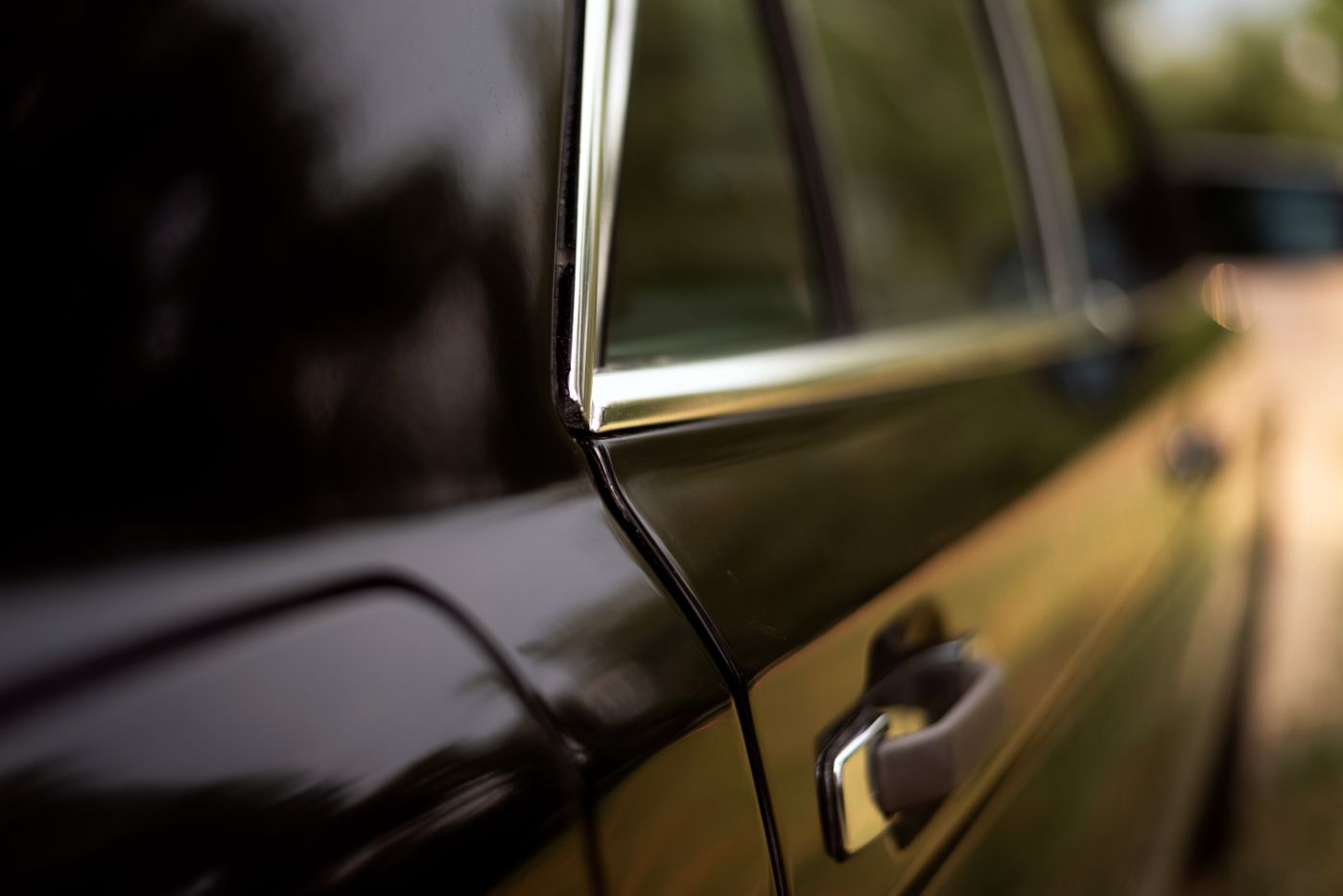 keychain for car keys — Detailed close-up of a vintage black car door featuring chrome trim and handle, capturing elegant design