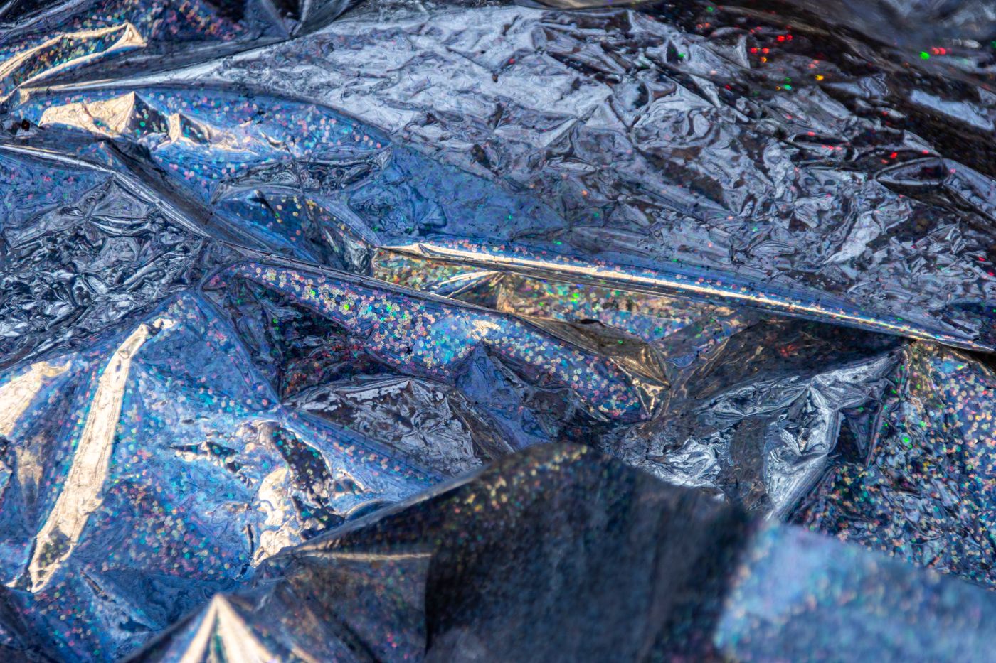 holographic stickers — A close-up view of colorful crumpled metallic foil with reflective and sparkling textures