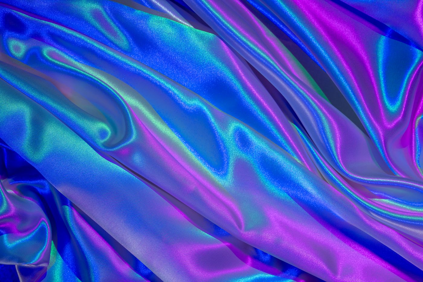 holographic stickers — A close-up of vibrant satin fabric in hues of blue and purple, showcasing a colorful ripple effect